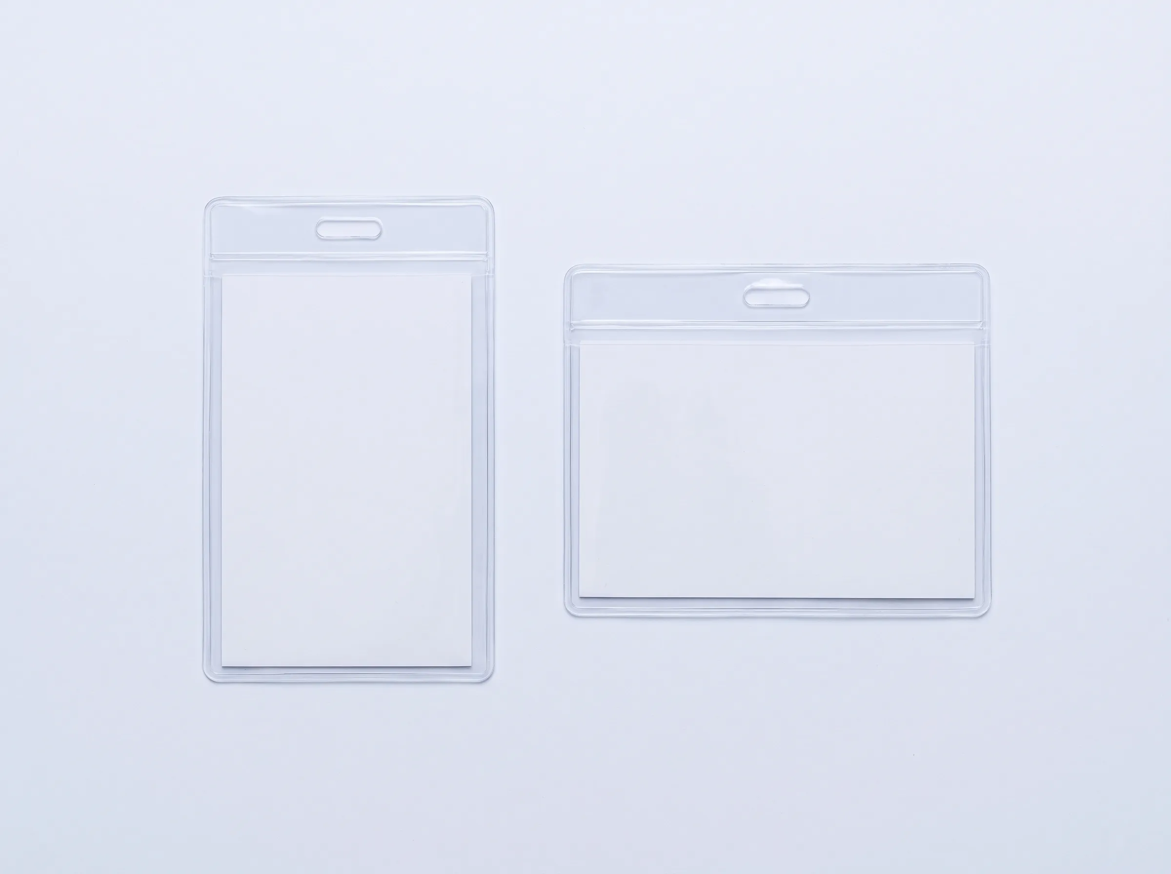 Two clear lanyard pouches of the same size shown side by side, one portrait and one landscape, each with the lanyard slot on its top short edge.